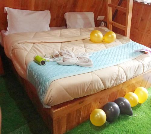 a bed with a bunch of balloons on the floor at KAIRA HUTs in Manāli
