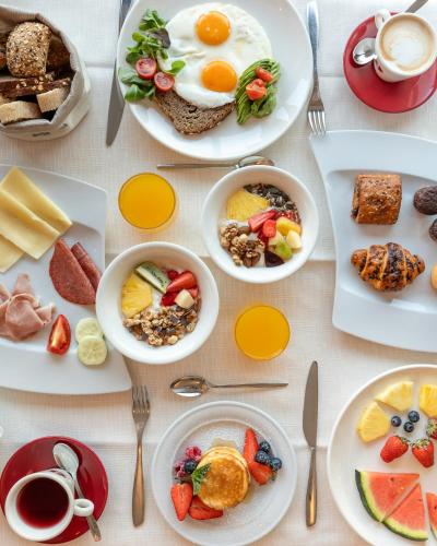 a table with plates of breakfast foods and drinks at Hotel Italia in Garda