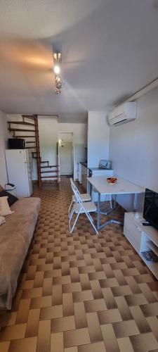 un salon avec un bureau et une table dans l'établissement Maison 5 couchages, Clim, Accès plage 100m, à Port-Leucate