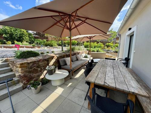 a patio with a wooden table and an umbrella at Private house with garden in Nový Jáchymov