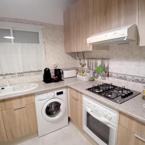a kitchen with a washing machine and a stove at Apartment Oásis Comfort in Portimão
