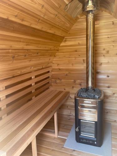 a small room with a stove in a wooden cabin at Au temps suspendu in Champagney