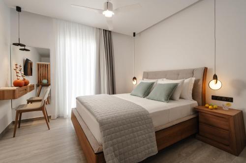 a bedroom with a bed and a desk with a chair at Phaistos Suites in Agios Prokopios