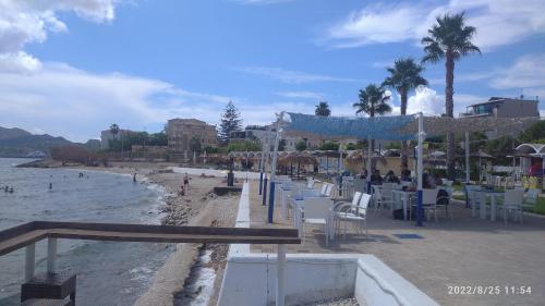 a beach with tables and chairs and the ocean at Miriam Luxury apartment in Zakynthos Town