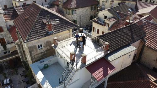 two people standing on a balcony of a building with roofs at Majka 2 Apartments in Kotor