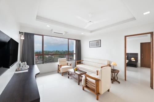 a living room with a couch and a tv at BSG Porvorim Regency Hotel Goa in Porvorim