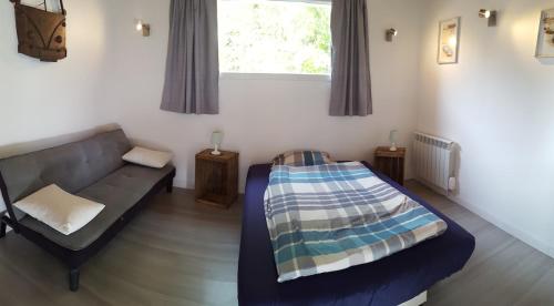 un salon avec un canapé et un lit dans l'établissement La Maison de Valérie, à La Flèche