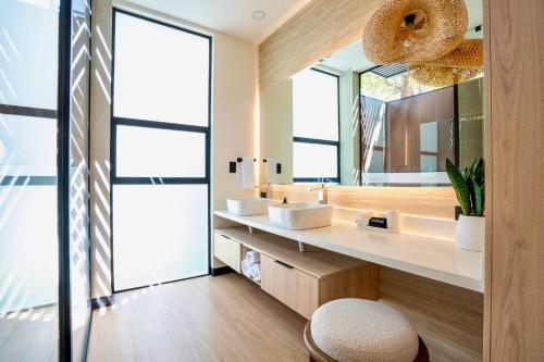 a bathroom with two sinks and a large mirror at Epic Tamarindo Boutique Hotel in Tamarindo