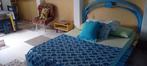 a bedroom with a blue bed with a chair and a chair at GRUTA da Praia 2 in Saquarema