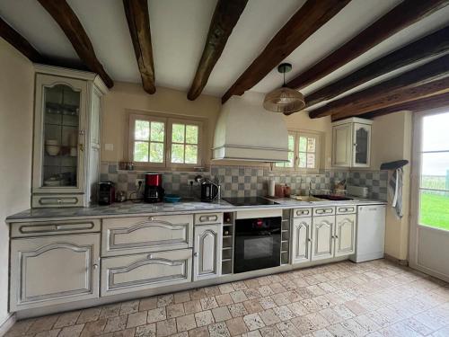 une grande cuisine avec des armoires et des appareils blancs dans l'établissement Country house - 75 min to Paris, à Saint-Maixme-Hauterive