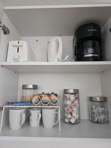 a shelf with cups and other kitchen items in a refrigerator at Sunset Cove in Buccoo