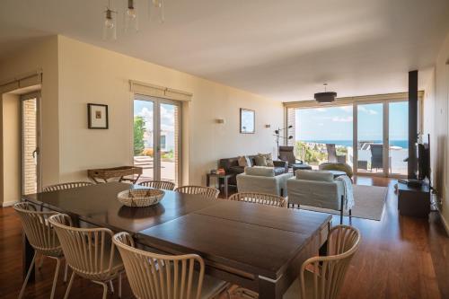 a living room with a table and chairs at Casa dos Ciprestes in Ericeira