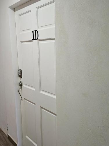 a white door with the number on it at Sunset Cove in Buccoo