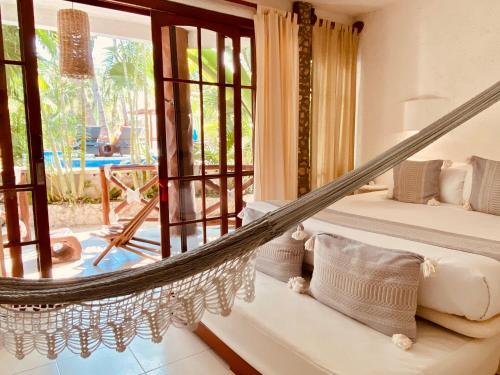 a hammock in a room with a view of the pool at Hotel Para Ti - Adults Only in Holbox Island