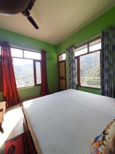 a bedroom with a large bed and two windows at The Wangdu in Rewalsar