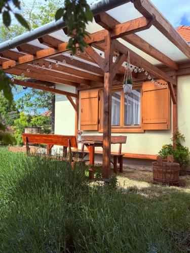 a wooden pergola with a picnic table and a bench at Ubytování TradiceJinak in Dolní Dunajovice
