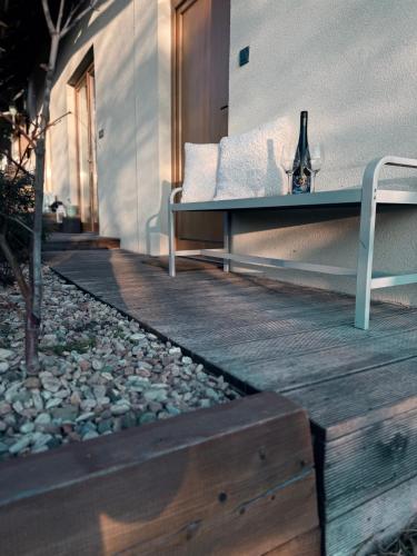 a bench sitting on a wooden deck next to a building at Ubytování TradiceJinak in Dolní Dunajovice