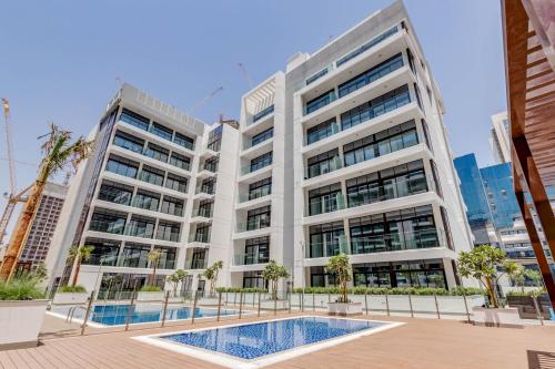 a large building with a swimming pool in front of it at GLOBALSTAY Azizi Riviera 59 in Dubai