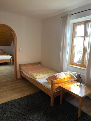 a bedroom with a bed and a table and a window at Ferienwohnung Haus Sutter in Schopfheim