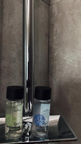 two bottles of moisturizers sitting on a bathroom sink at Epic Studios Kallithea in Kallithea Halkidikis