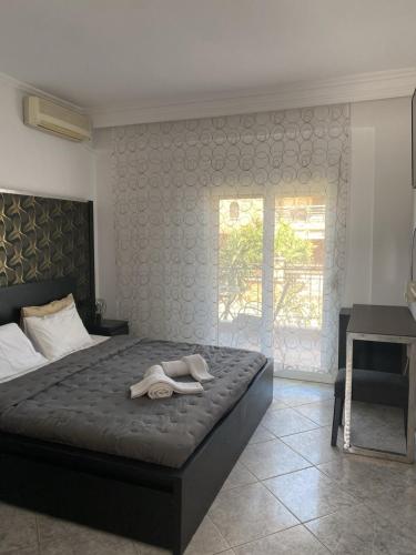 a bedroom with a bed with two shoes on it at Epic Studios Kallithea in Kallithea Halkidikis