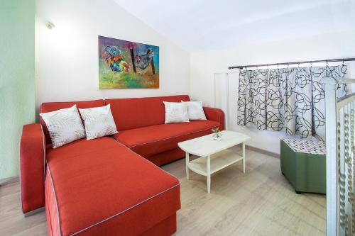 a living room with a red couch and a table at Syrainas studios in Troulos