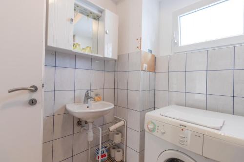 a bathroom with a sink and a washing machine at Apartment DN 12 in Baška