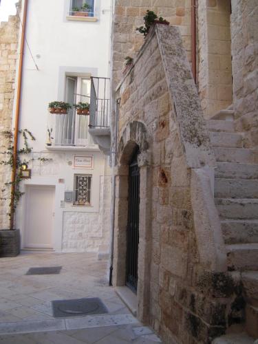 an alley with a stone building with a door and stairs at B&B Casa Dorsi in Polignano a Mare