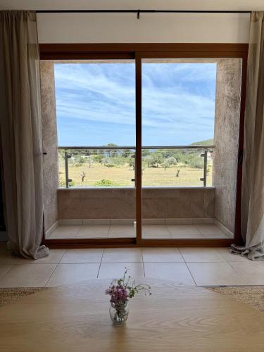 a vase of flowers in a room with a large window at Agroturismo Sa Marina - Adults Only in Cala Boix