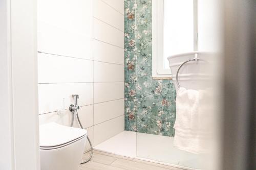a bathroom with a toilet and a window at Casa Gemelli a pochi passi da spiaggia Su Giudeu Chia in Chia
