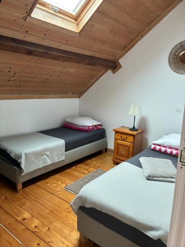 a bedroom with two beds and a skylight at Gîte au Bon Accueil Therence in Sainte-Thérence