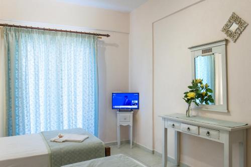 a room with two beds and a television in it at Syrainas studios in Troulos