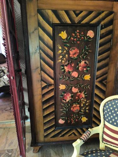 a painting of flowers on a wall next to a chair at Tamerici House in Montecastrilli