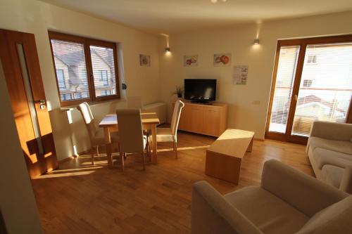 a living room with a table and chairs and a couch at Baltic Vip Apartamenty blisko morza in Rewal