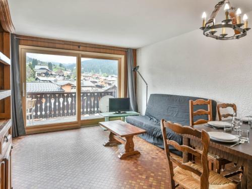 un salon avec un canapé et une table dans l'établissement Appartement 1 chambre, proche centre, parking et équipements modernes - FR-1-685-82, aux Gets