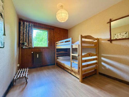 une chambre avec deux lits superposés et une fenêtre dans l'établissement Appartement au pied des pistes, proche commodités, balcon, parking, calme - FR-1-505-8, à Notre-Dame-de-Bellecombe
