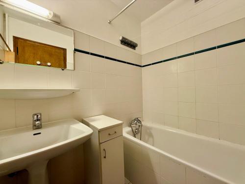une salle de bain blanche avec un lavabo et une baignoire dans l'établissement Appartement au pied des pistes, proche commodités, balcon, parking, calme - FR-1-505-8, à Notre-Dame-de-Bellecombe