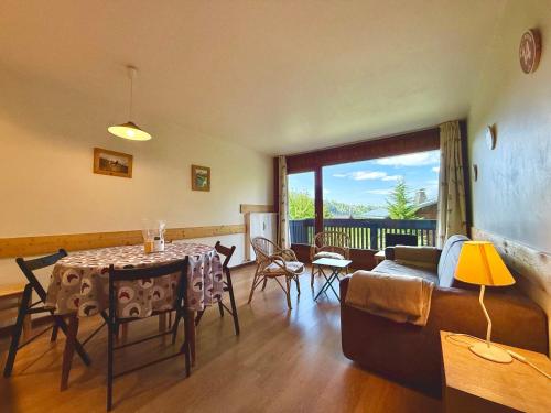 un salon avec une table et un canapé dans l'établissement Appartement au pied des pistes, proche commodités, balcon, parking, calme - FR-1-505-8, à Notre-Dame-de-Bellecombe