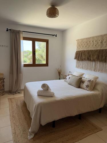 a bedroom with a large bed with a towel on it at Agroturismo Sa Marina - Adults Only in Cala Boix