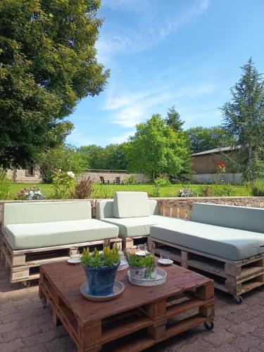 a patio with two couches and a table with a coffee table at Maison de charme in Tour-en-Bessin