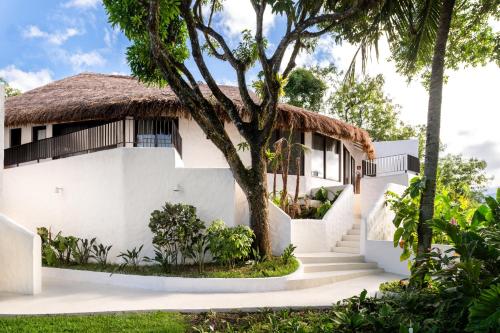 a white house with a thatched roof at Miradouro de São Sebastião in São Sebastião