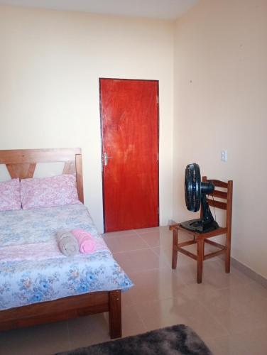 a bedroom with a bed and a red door at Hosting in Camocim in Camocim