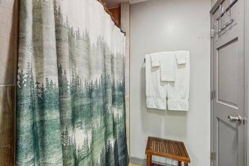 a bathroom with a shower curtain with a forest print at Skyleaf Villa 702 in Sugar Mountain