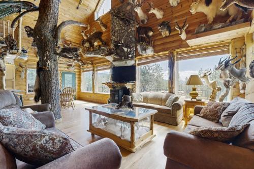 a living room with couches and a fireplace in a log cabin at Hunter's Paradise in New Meadows
