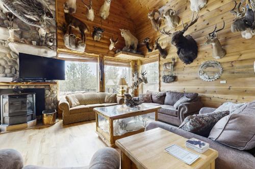 a living room with a log wall with antlers at Hunter's Paradise in New Meadows