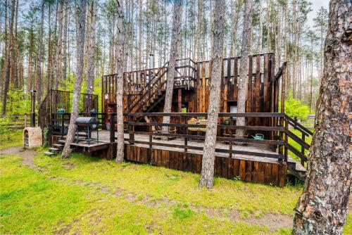 a wooden cabin in the middle of a forest at Domek lubiana180 SCANDI wśród drzew jacuzzi taras na dachu jezioro Kaszuby Pieski tylko do 10kg za dodatkową opłatą in Grzybowo