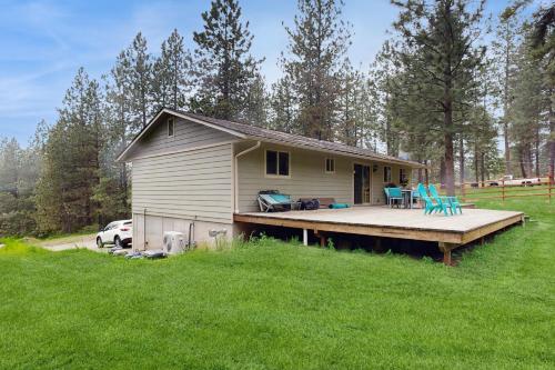 a small house with a deck in a field at Gold Rush Deck in Coeur d'Alene