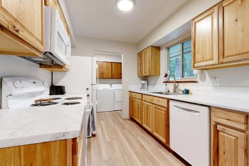a kitchen with white appliances and wooden cabinets at Gold Rush Deck in Coeur d'Alene