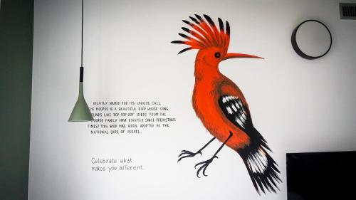 a painting of a red bird on a wall at YellowSquare Milan in Milan