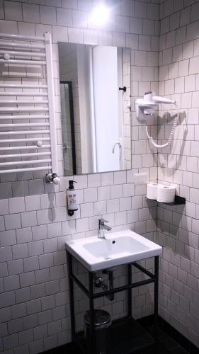 a white bathroom with a sink and a mirror at YellowSquare Milan in Milan